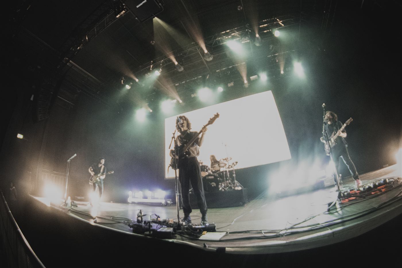 The band on a big stage in front of a projection screen