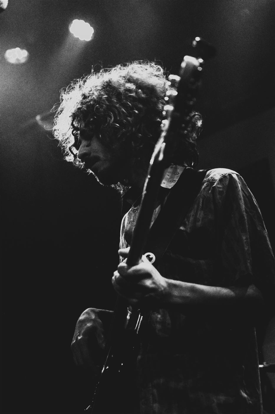 Close-up of the bassist playing under a spotlight