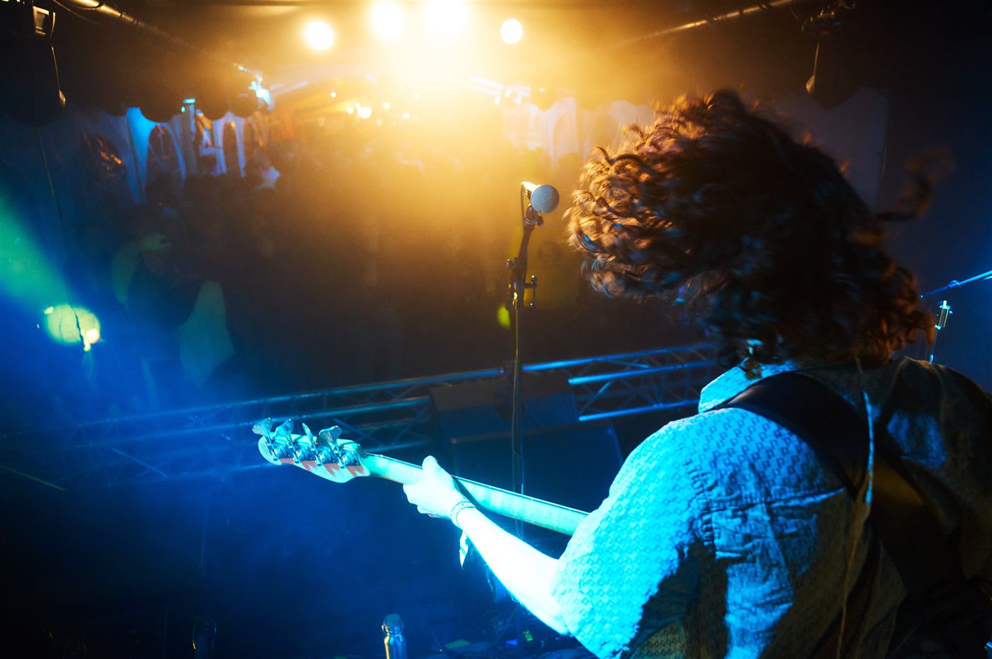 Bassist playing in blue and orange stage light